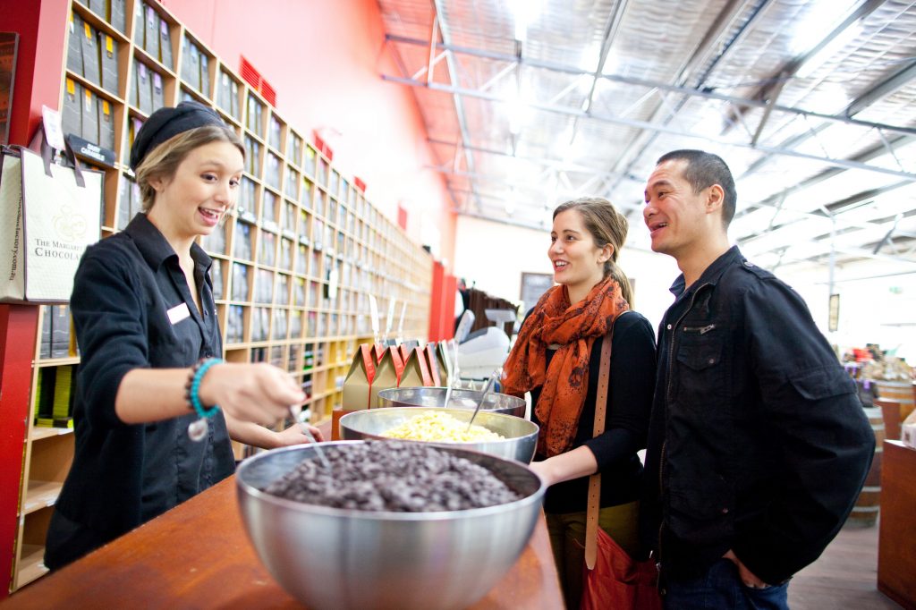 Customers enjoy a free sample from friendly employee at Margaret River Chocolate Factory in Western Australia