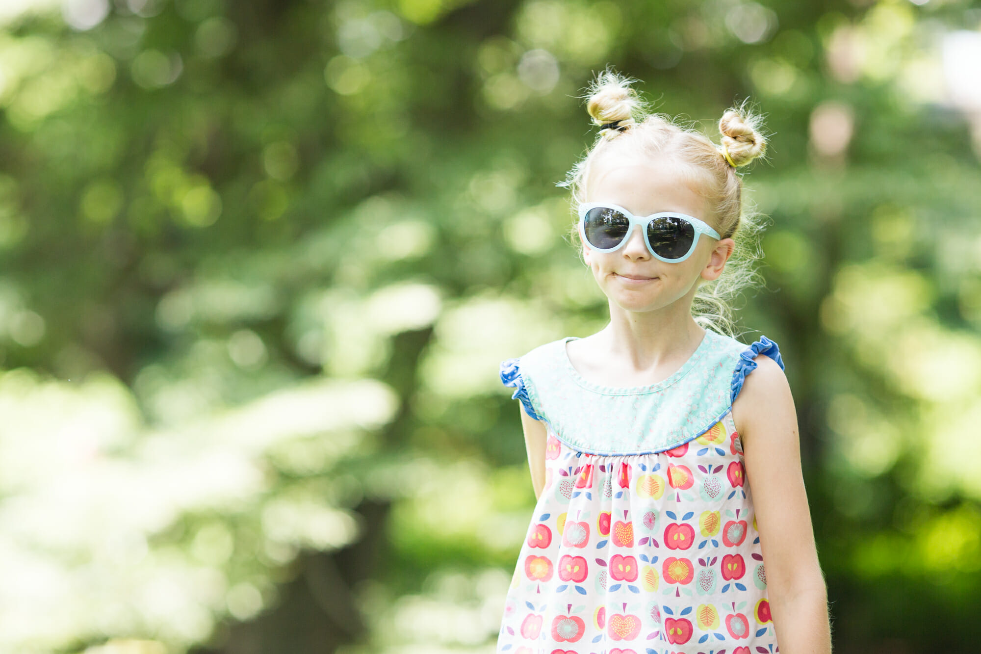 A portrait of a girl in a park with sunglasses