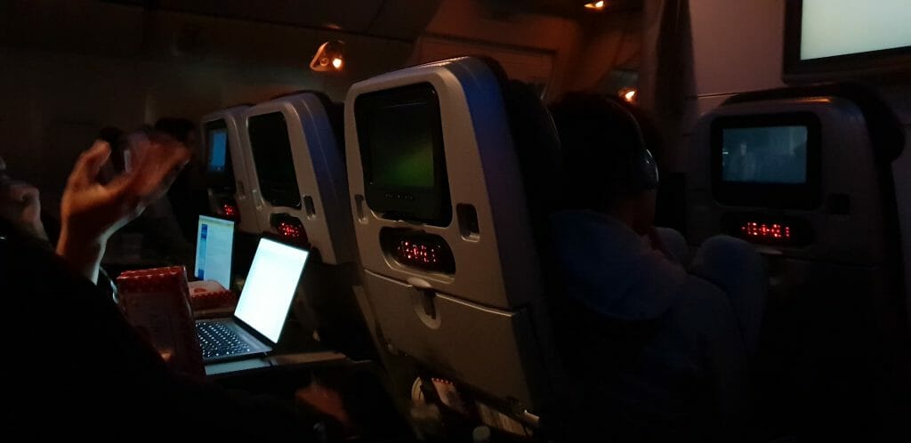 Passengers use laptops on a flight