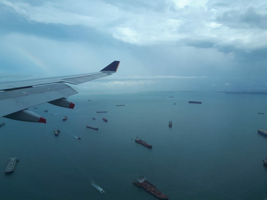 View of boats on ocean through plane window