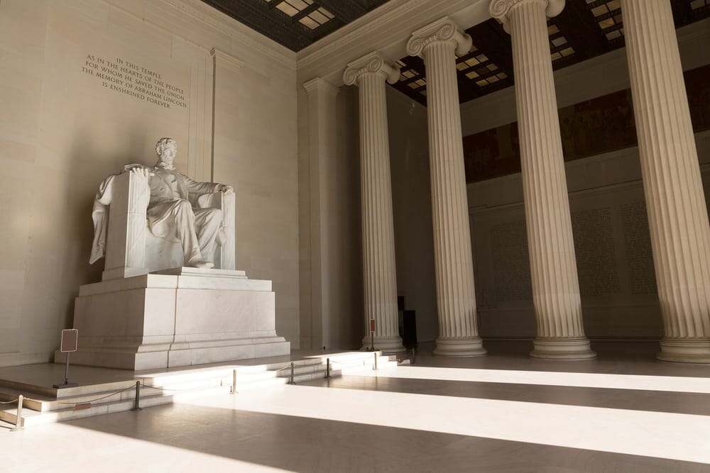 Statue of Abraham Lincoln beside columns in Lincoln Memorial