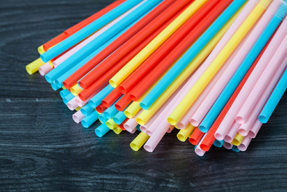 Packet of colourful plastic straws on table
