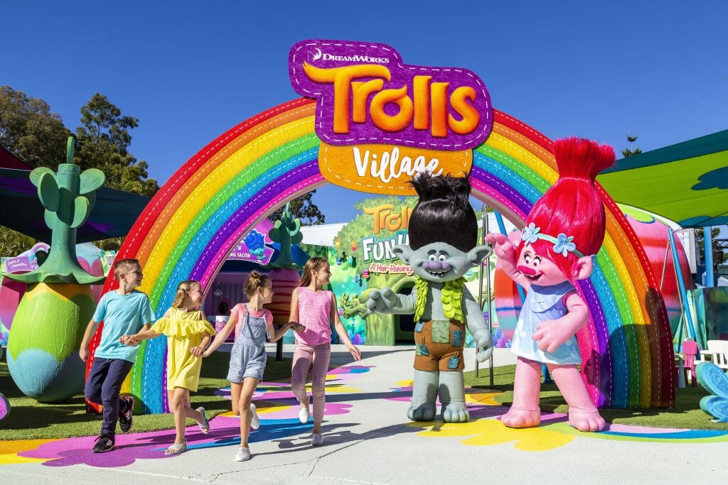 Kids waving goodbye to Trolls characters outside DreamWorks Trolls Village Dream World