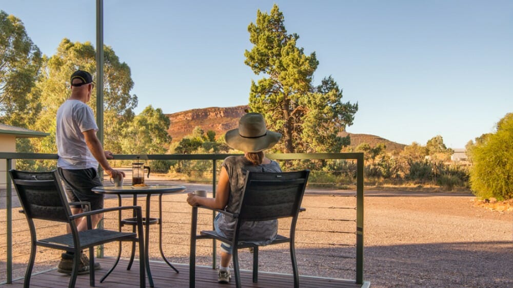 couple enjoying happy hour on desk at rawsnley Part Station in Ikara Flinders Ranges National Park