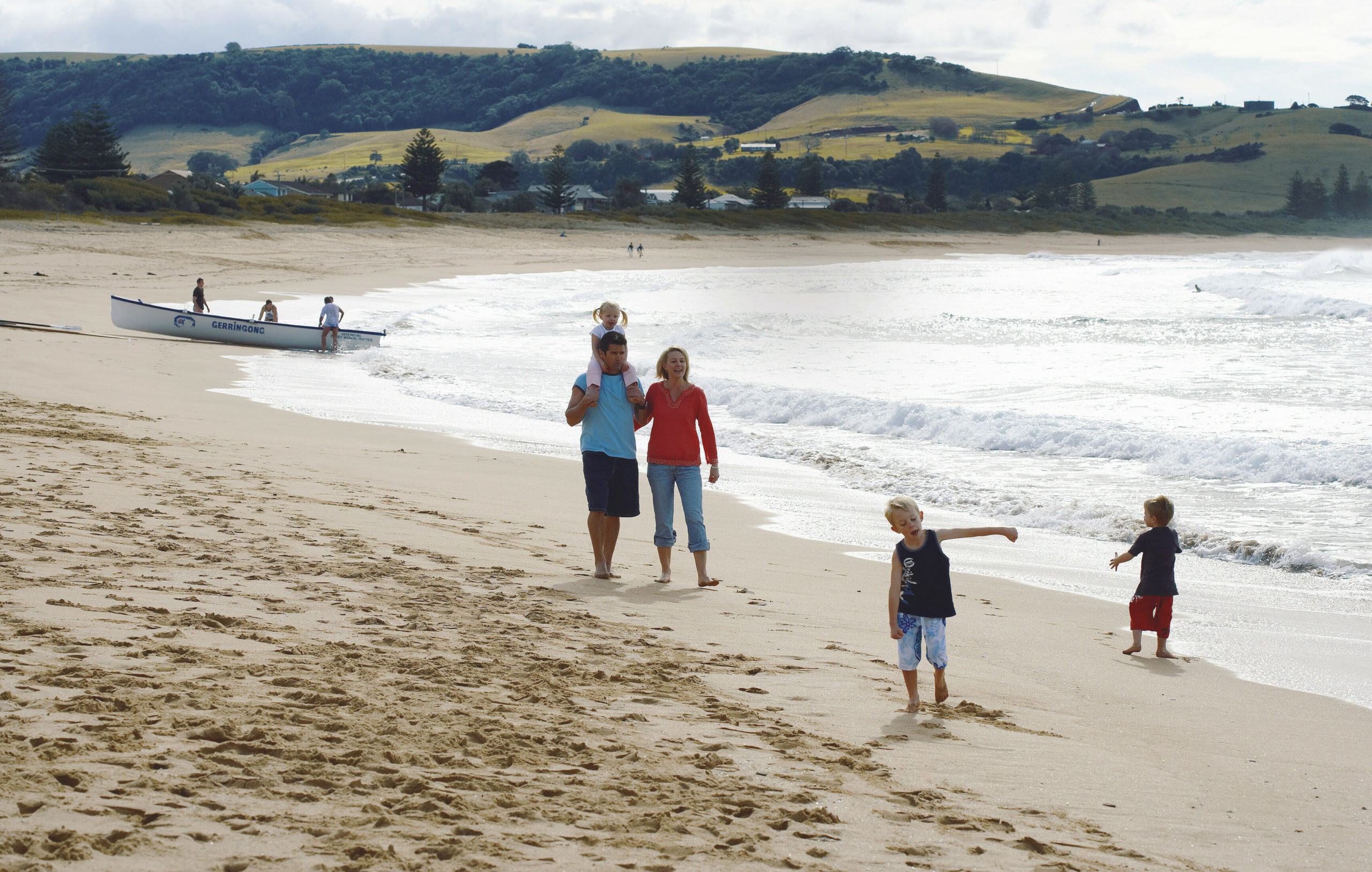 Family walking along Kiama beach, Illawarra, South Coast
