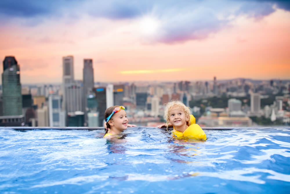 Kids swimming in rooftop infinity pool in Singapore