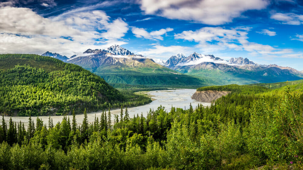 scenery shot: Snow-capped mountain, green trees and blue lake