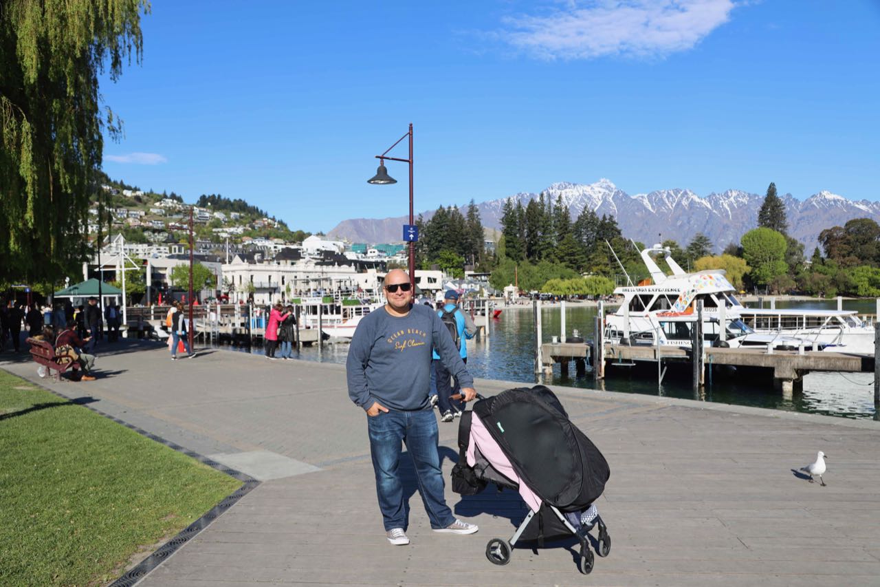 man with a baby in a pram in Queenstwon, New Zealand