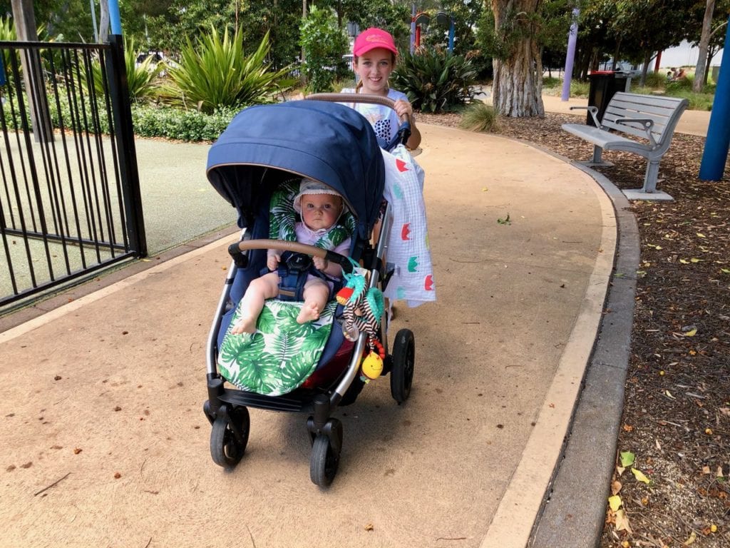 a young girl pushing a baby in a pram at Speers Point Park, Lake Macquarie.