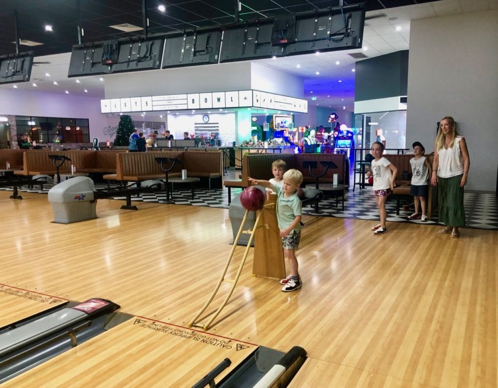 a young boy trying ten pin bowling for the first time