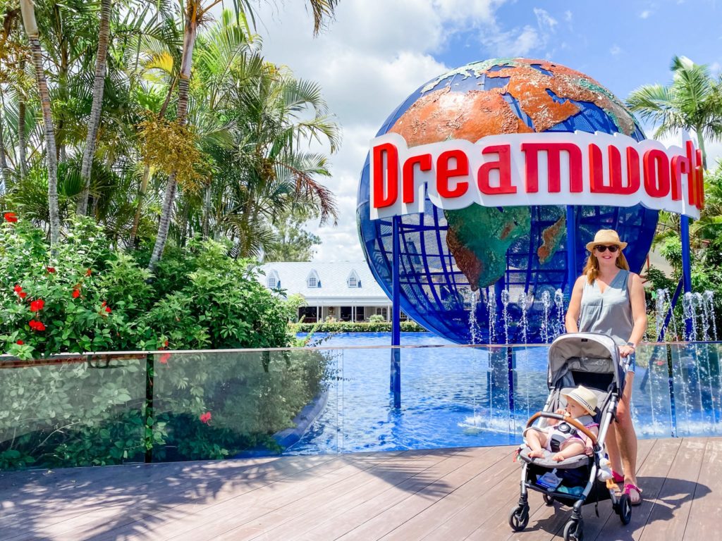 mother with baby in a pram in front of the Dreamworld globe at Dreamworld on the Gold Coast