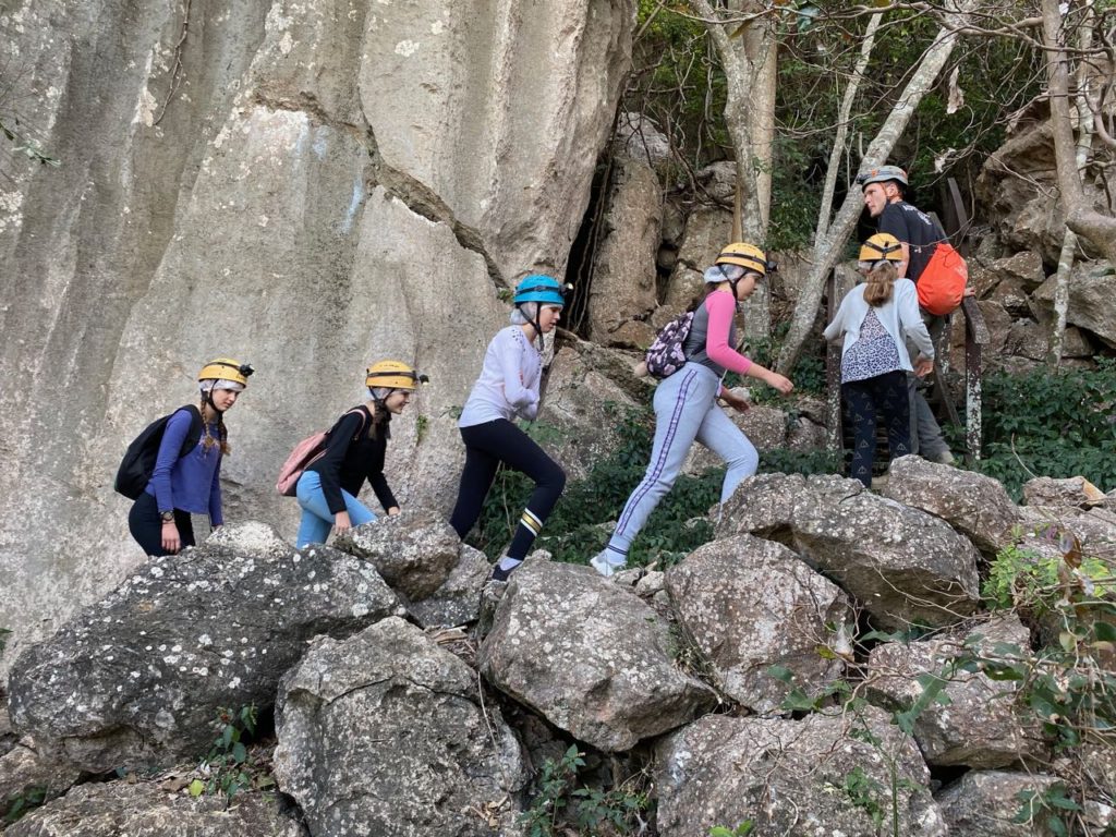 kids and their parents walking amongst the rocks wearing head torches at Capricorn Caves