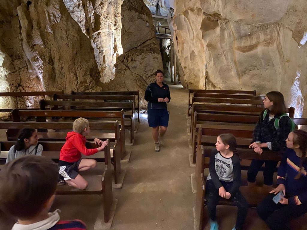 Inside the cathedral at Capricorn caves, kids listen to their guide
