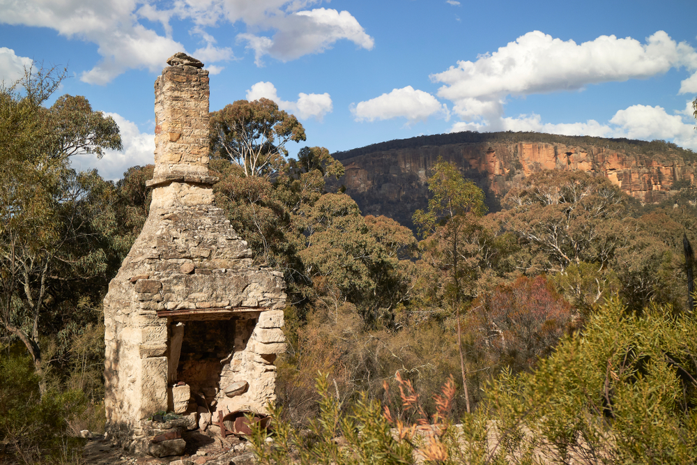 chimney ruin in front of mountain escarpment in Capertee National Park
