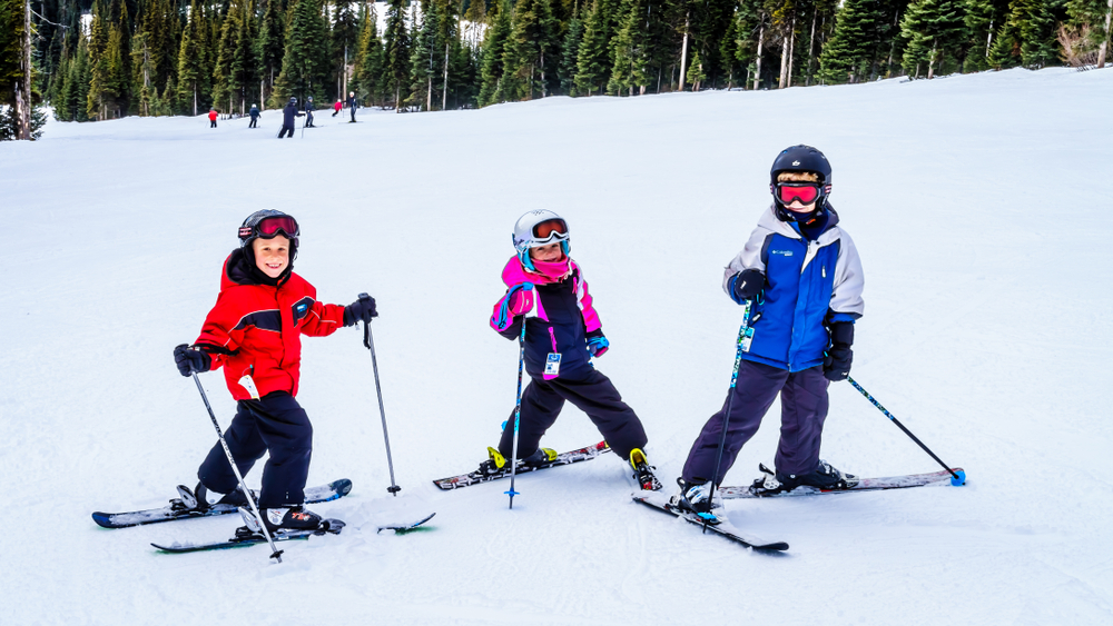 Kids on skis having fun on a white Christmas holiday at Sun Peaks in British Columbia