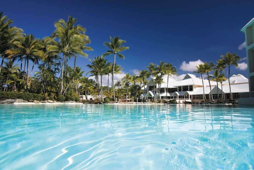 hotel pool fringed by palm trees at the Sheraton Grand Mirage in Port Douglas