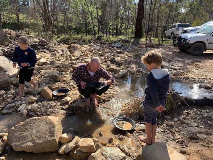 A father and two sons try their luck gold panning on a creek near Bathurst