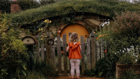 small child looking at hobbit house door at Hobbiton