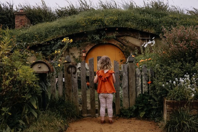 small child looking at hobbit house door at Hobbiton