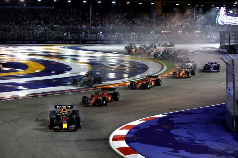 Red Bull's Sergio Perez leads the race in the opening lap as the cars tackle the initial turns of the Marina Bay Street Circuit