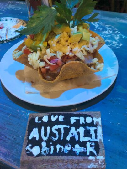 Colorful taco bowl with avocado and parsley on top with a sign saying "Love From Australia" in front of it